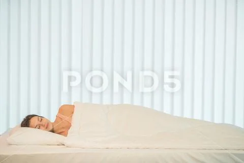 The pretty woman sleeping in the bed with a white linens Stock Photos