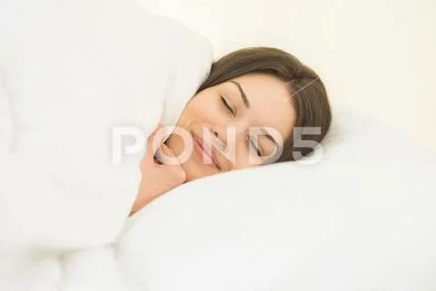 The pretty woman sleeping in the white linens Stock Photos