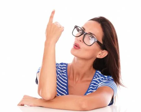 Pretty woman with spectacles pointing up while looking at camera in white bac Stock Photos