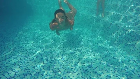 Pretty woman swimming underwater in pool, slow motion Stock Footage