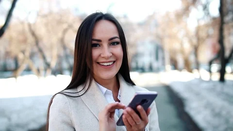 Pretty woman using her smartphone outdoors Stock Footage 88284010