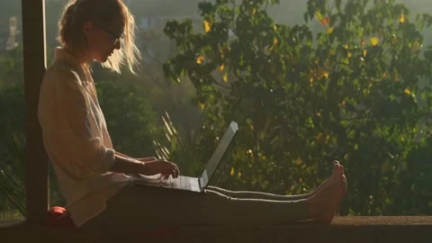 Pretty woman using laptop while sitting on the rooftop in sunlight. Stock Footage 237002499