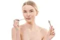The pretty woman using a lip gloss on the white background Photo