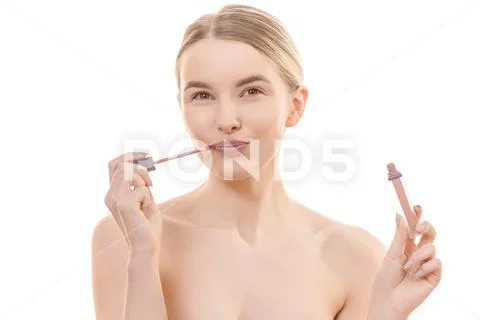 The pretty woman using a lip gloss on the white background Stock Photos