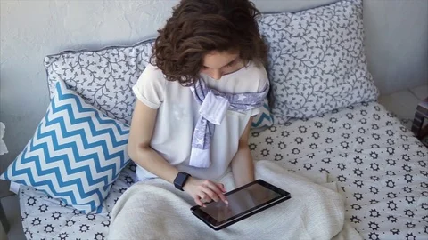 Pretty woman using tablet computer online shopping at home sitting on bed. Video stock 74313731