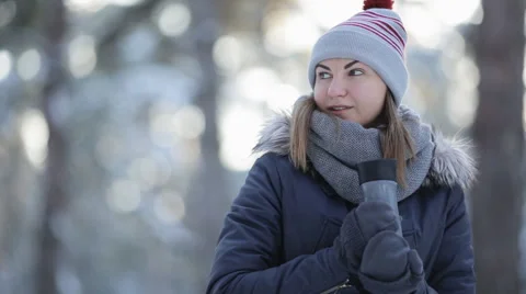 Pretty woman in winter hat enjoys the snow and drinks hot beverage Video stock 59658032