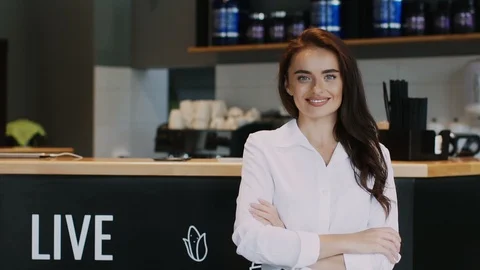 Pretty worker in formal clothes pointing to something on arm in the cafe Stock Footage 113864186
