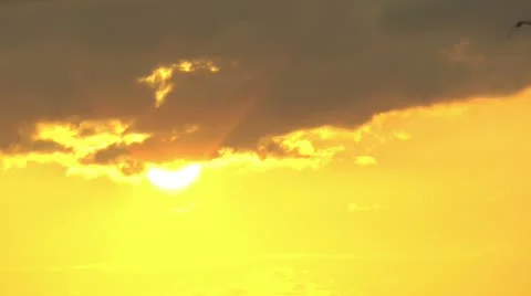 Pretty yellow sky and sun partially behind some clouds Stock Footage 11092852