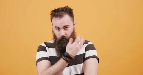 Pretty young bearded man dressed in a t-shirt in front of yellow background Stock Footage 104052712