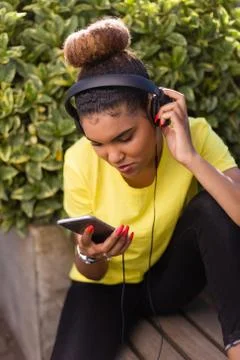Pretty young black african american woman listening to music with a headphone Stock Photos