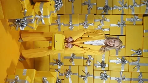 A pretty young blonde, dressed in a yellow suit, poses in front of the camera Stock Footage 165098295