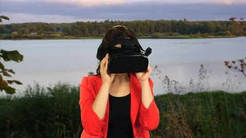 Pretty young caucasian model using VR headset on nature background. Stock-Footage 100039480