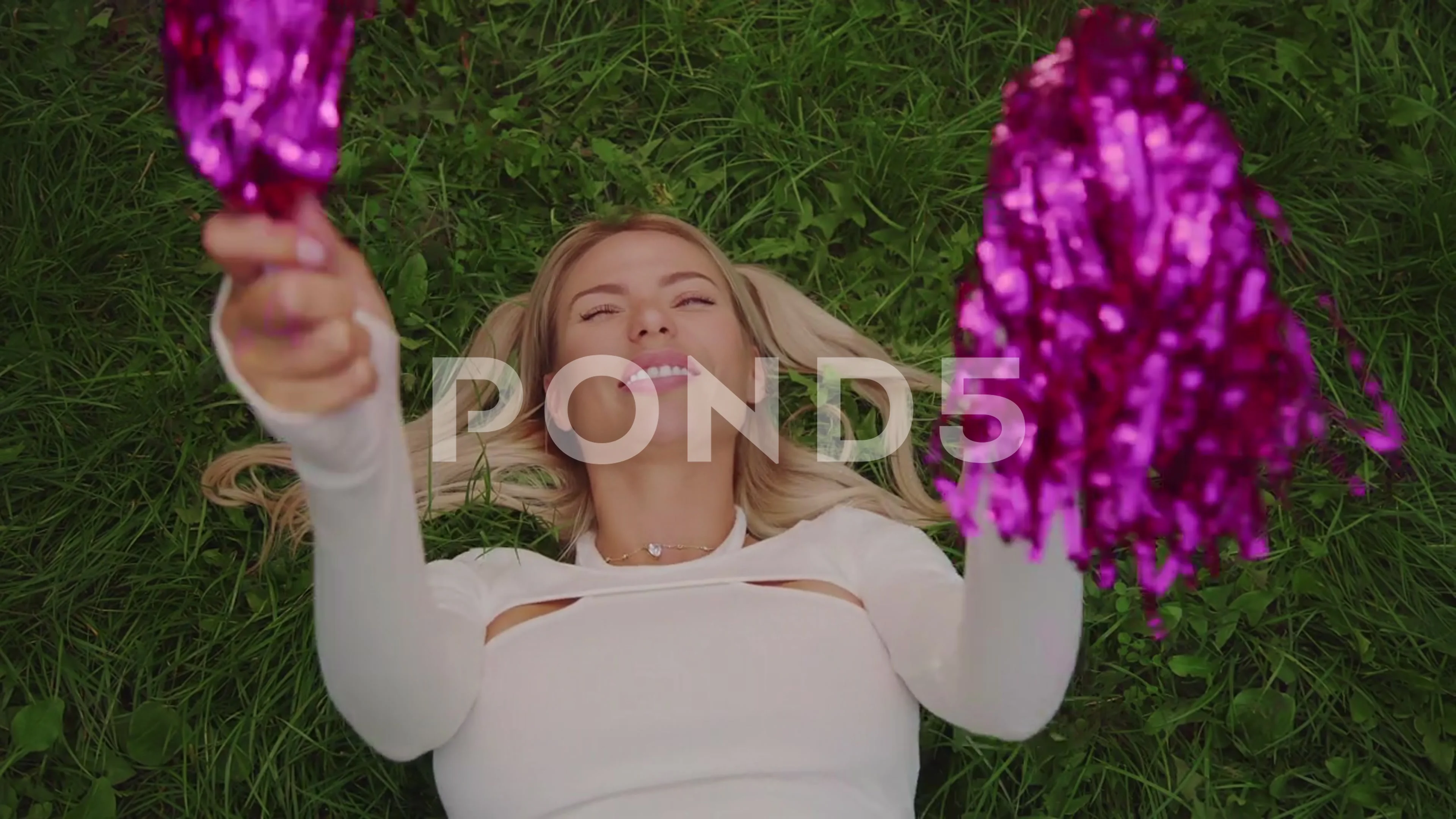 A cheerleader shakes her pom-poms smiles and encourages action