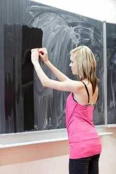 Pretty young college student erasing the chalkboard/blackboard d 스톡 사진