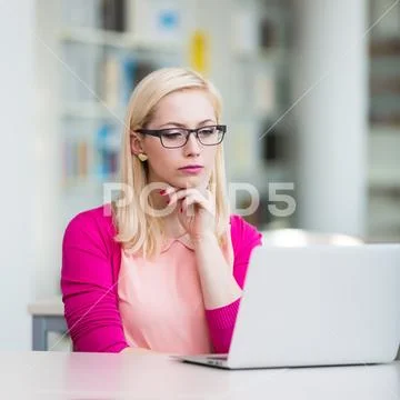 Pretty young college student in a library (shallow DOF; color toned image) Stock Photos