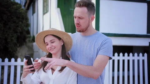Pretty young couple exploring new social media application on smartphone in cosy Stock Footage 107271539
