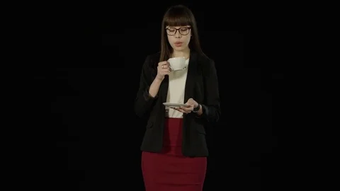 Pretty young girl holding a cup of hot drink and blowing on it Stock Footage