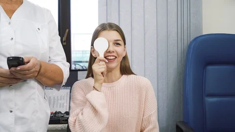 Pretty young girl model is checking her eyesight by closing one eye. Stock Footage 121753986