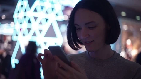Pretty young girl smiling using smartphone chatting online in shopping mall Video stock 83369175