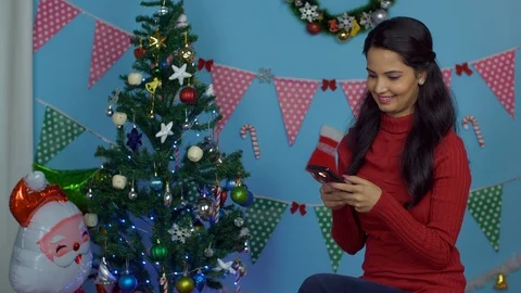 Pretty young girl using her mobile phone while doing Christmas preparations a... Stock Footage 120177543