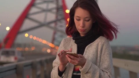 Pretty young girl using smart phone mobile in the city at night 스톡 동영상 79814742