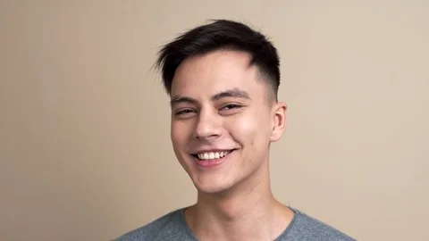Pretty young guy smiles and laughs to the camera in slow motion, video portrait Stock Footage 101276459