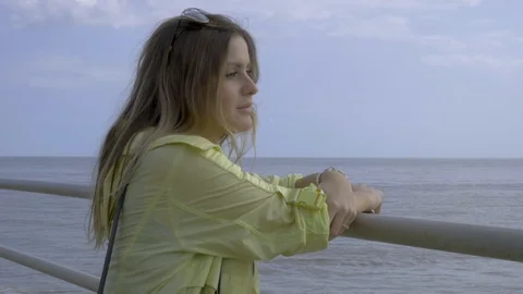 Pretty young lady with a thoughtful expression looks out to sea Stock Footage 97301953