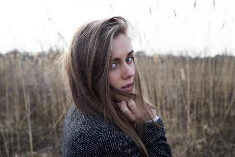 Pretty young model with long blond hair looks in camera out over her shoulder Stock Photos