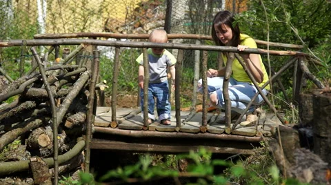 Pretty young mother with her cute little son playing on the bridge Stock Footage 63484936