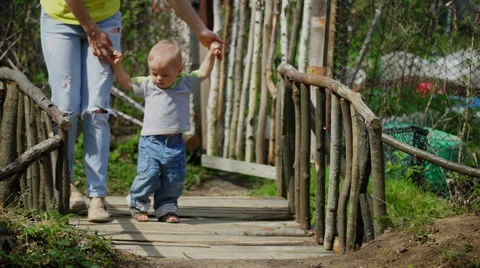 Pretty young mother with her cute little son come over the bridge Stock Footage 63486801
