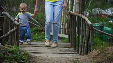 Pretty young mother with her cute little son come over the bridge Stock Footage 63487032