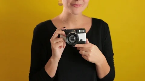 Pretty Young Woman using Camera On solid Yellow Background Stock Footage 95210426