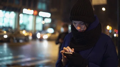 Pretty young woman using a cell phone checking mails walking on crossroad Video stock 83068508
