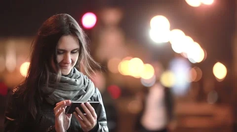 Pretty young woman using her smartphone at night. Lady in the street in cold Video stock 67950271
