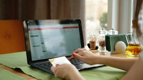 Pretty Young womans hands holding a credit card and using laptop computer for 스톡 동영상 100022980