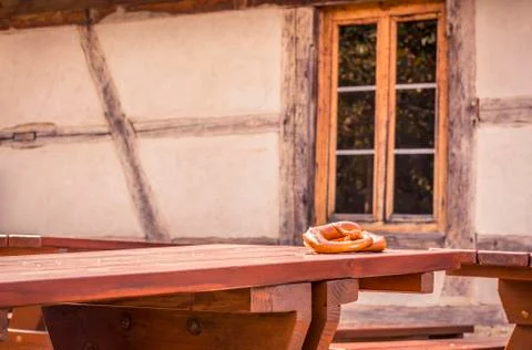 Pretzels on rustic table and German house background Stock Photos
