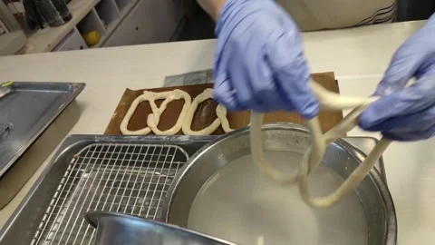 Pretzels soaking into warm water Stock Footage 265036655