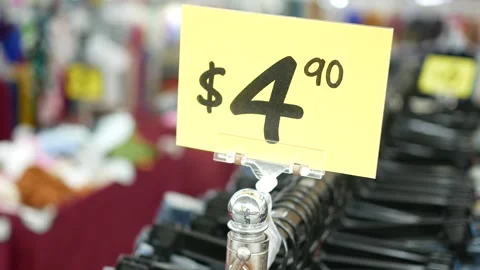 Price tag displaying four dollars and ninety cents on store clothing rack. Vídeos de archivo 332858634