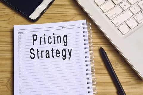 Pricing strategy label on notepad with laptop and smartphone Stock Photos