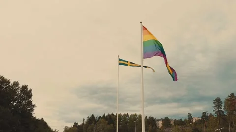 Pride flag and Swedish flag blowing in the wind - 13sec - 4k Stock Footage