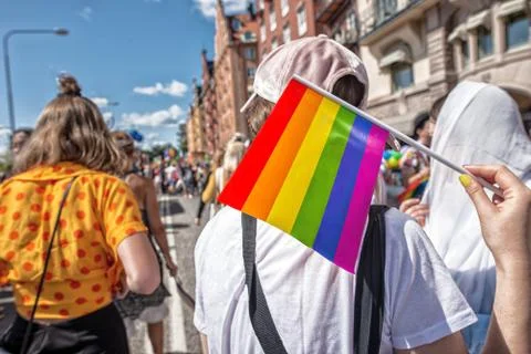 Pride flag in human hand on a pride parade Stock Photos