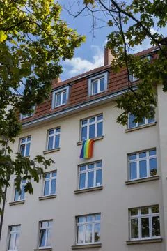 Pride flag on the window of the house Stock Photos