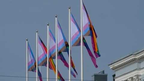 The Pride flags on a white flagpole against the blue sky. Stock Footage 139013643