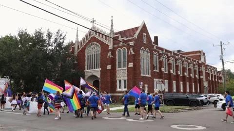 Pride Marchers With Flags Pass a Historic Church, Jacksonville, Florida Stock Footage 346920029