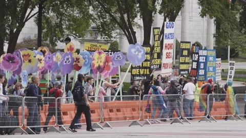 Pride parade spectators interact with extremists holding homophobic signs Stock Footage 274367737