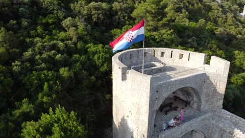 Pride of Ston: 4K Drone Close-up on Croatian Flag Atop Historic Walls Stock Footage 246611294