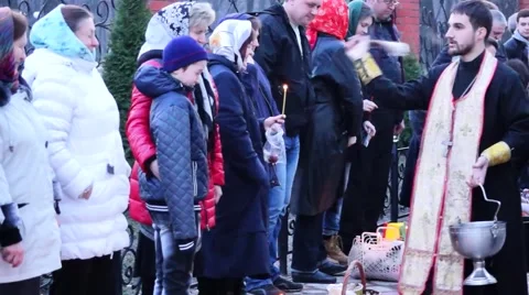 The priest blesses the Holy water of Easter cakes and people. Video stock 49129550
