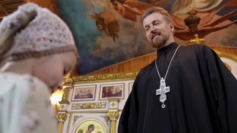 a priest blesses a little girl in a head... | Stock Video | Pond5