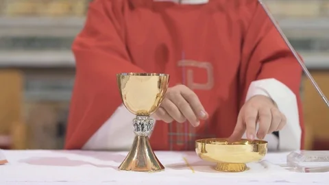 Priest breaking communion wafer Stockbeeldmateriaal 89974565