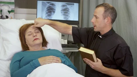 A priest delivers last rites to a woman | Stock Video | Pond5